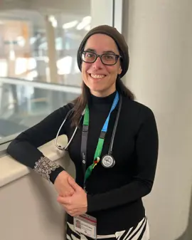 Dr. Orit Freedman smiling with her arm resting against a window sill.