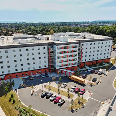Aerial view of hospital exterior with emergency vehicles and cars parked in front