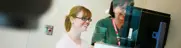 Mammography procedure, two staff reviewing  images on diagnostic screen