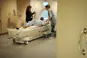 Patient escorted to MRI machine with two staff assisting carefully