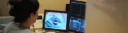 MRI screen displaying scan results while medical staff observes attentively nearby