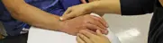 Hand therapy session with patient’s hand carefully examined by clinical staff