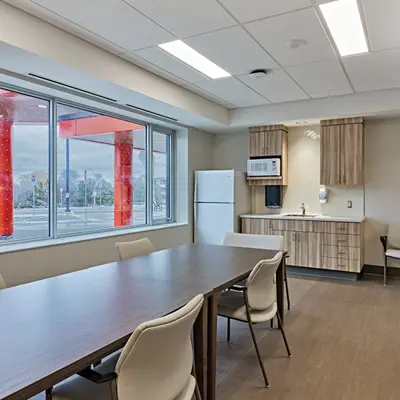 Dining and activity space featuring long table with arranged seating in large hall