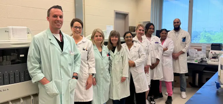 Group photo of Laboratory Medicine team in uniform with medical devices nearby