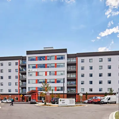 Hospital exterior view showing emergency vehicles and other cars parked at main entrance