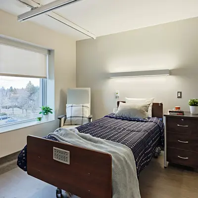 Resident room bedroom, well-lit, organized, clean, and furnished in modern style